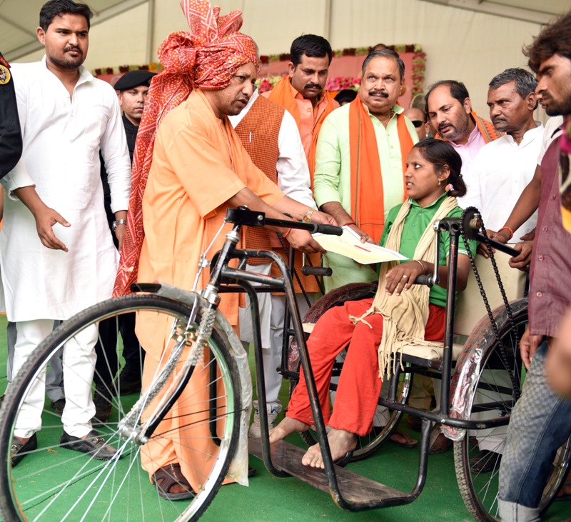 UPCM दिव्यांगजन को ट्राईसाइकिल सहित अन्य उपकरण प्रदान करते हुए