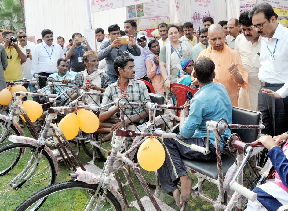 UPCM द्वारा जनपद सीतापुर में दिव्यांगजन को ट्राईसाइकिल प्रदान करते हुए