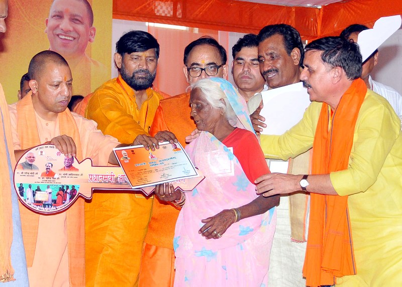 UPCM भदोही में लाभार्थी को प्रधानमन्त्री आवास योजना की कुंजी और प्रमाण पत्र भेंट करते हुए