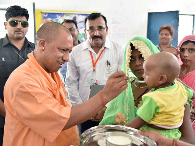 UPCM मिनी आंगनबाडी केन्द्र में अन्नप्राशन में बच्चे को खीर खिलाते हुए