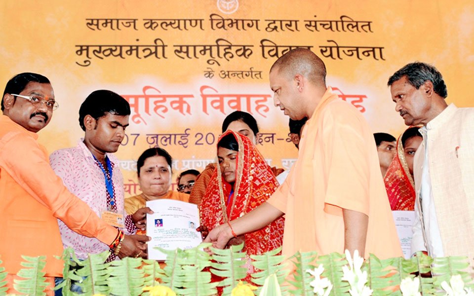 UPCM सामूहिक विवाह समारोह में नव विवाहित दंपत्तियों को प्रमाण-पत्र प्रदान करते हुए