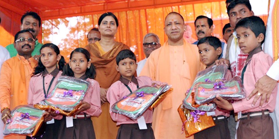UPCM सोनभद्र में कार्यक्रम के दौरान बच्चों को स्कूल बैग, यूनीफाॅर्म आदि वितरित करते हुए