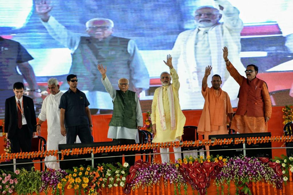 UPCM , PM मोदी और राज्यपाल मंच से जनता का अभिनन्दन करते हुए