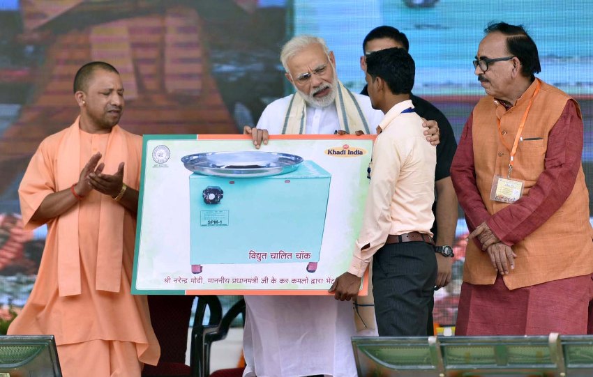 PM मोदी वाराणसी में लाभार्थियों को प्रमाण पत्र प्रदान करते हुए