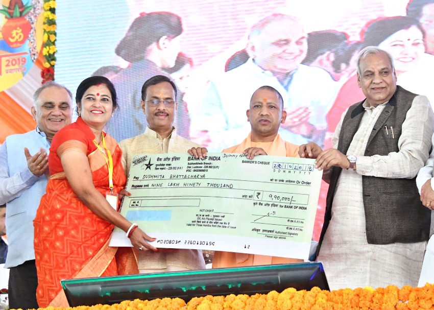 UPCM उद्यमियों को ऋण धनराशि के प्रतीकात्मक चेक वितरित करते हुए