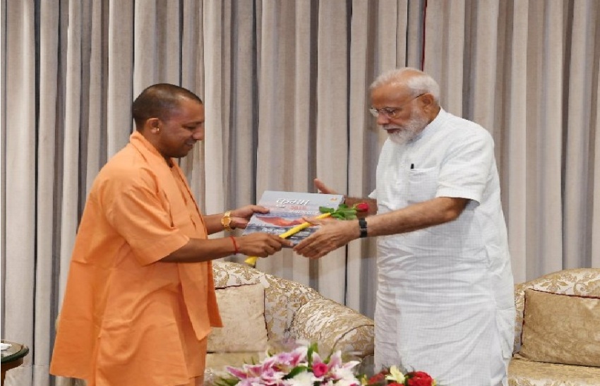 UPCM-योगी PM-नरेन्द्र मोदी को कुम्भ की पुस्तक भेंट करते हुए