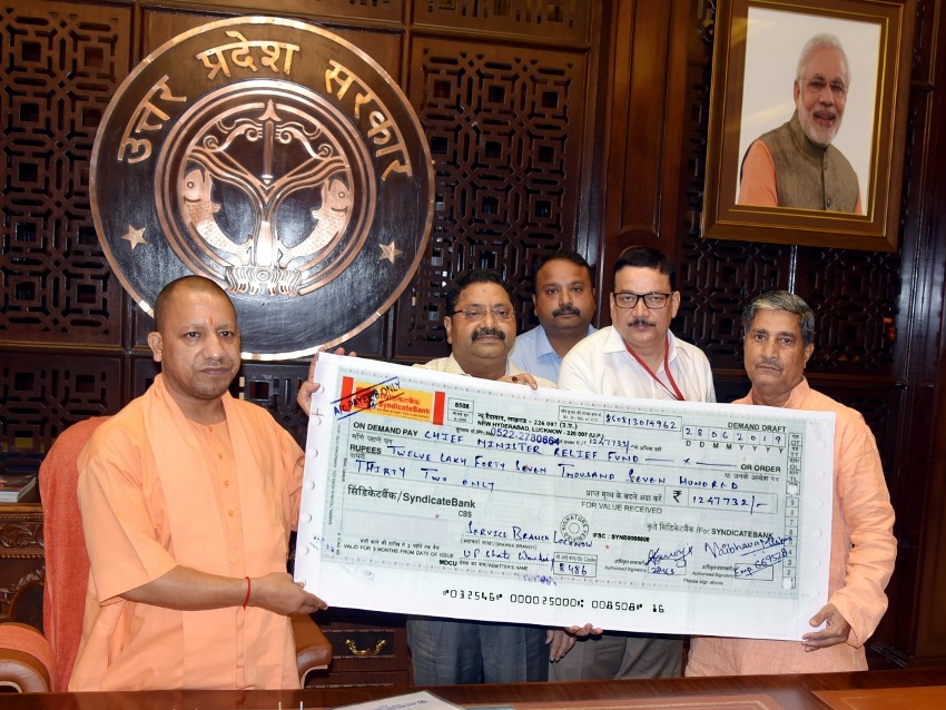 UPCM योगी आदित्यनाथ को सहकारिता मंत्री चेक भेंट करते हुए