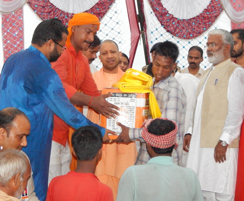 UPCM योगी बलिया में बाढ़ पीड़ितों को राहत सामग्री का वितरण करते हुए