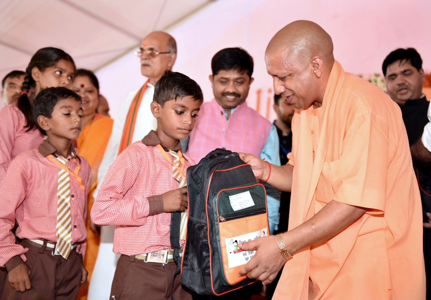 UPCM योगी चित्रकूट में स्कूली बच्चों को स्कूल बैग वितरित करते हुए